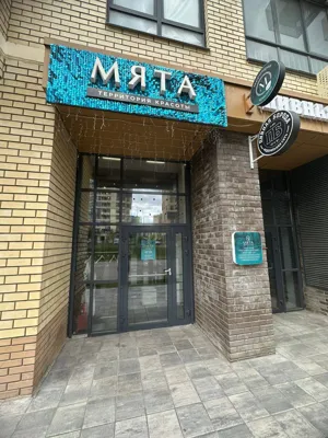 Световая вывеска салона красоты «Мята» с объёмными буквами на фасаде жилого дома